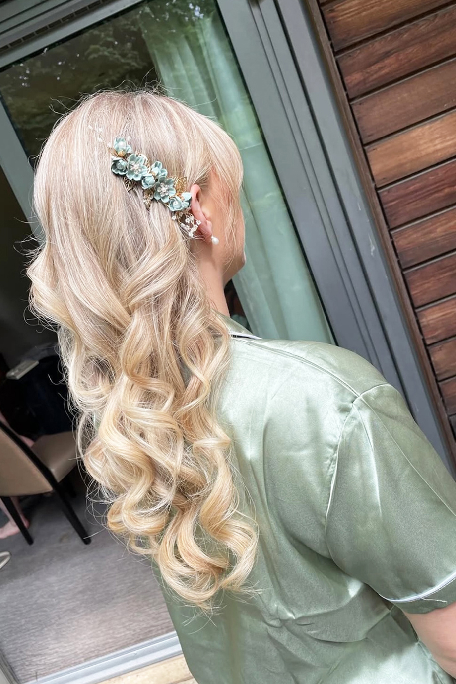 Bridesmaid in green satin pyjamas and long blonde curled hair with green hair clip